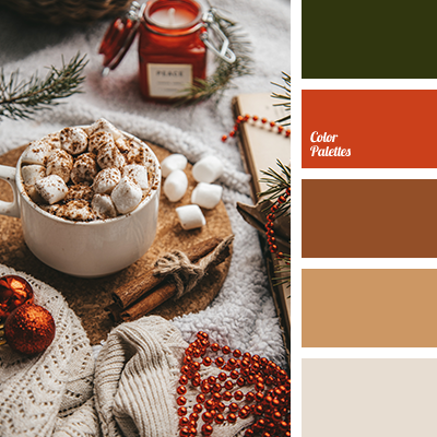 Cozy holiday scene with hot chocolate topped with marshmallows, candle, and winter decorations.