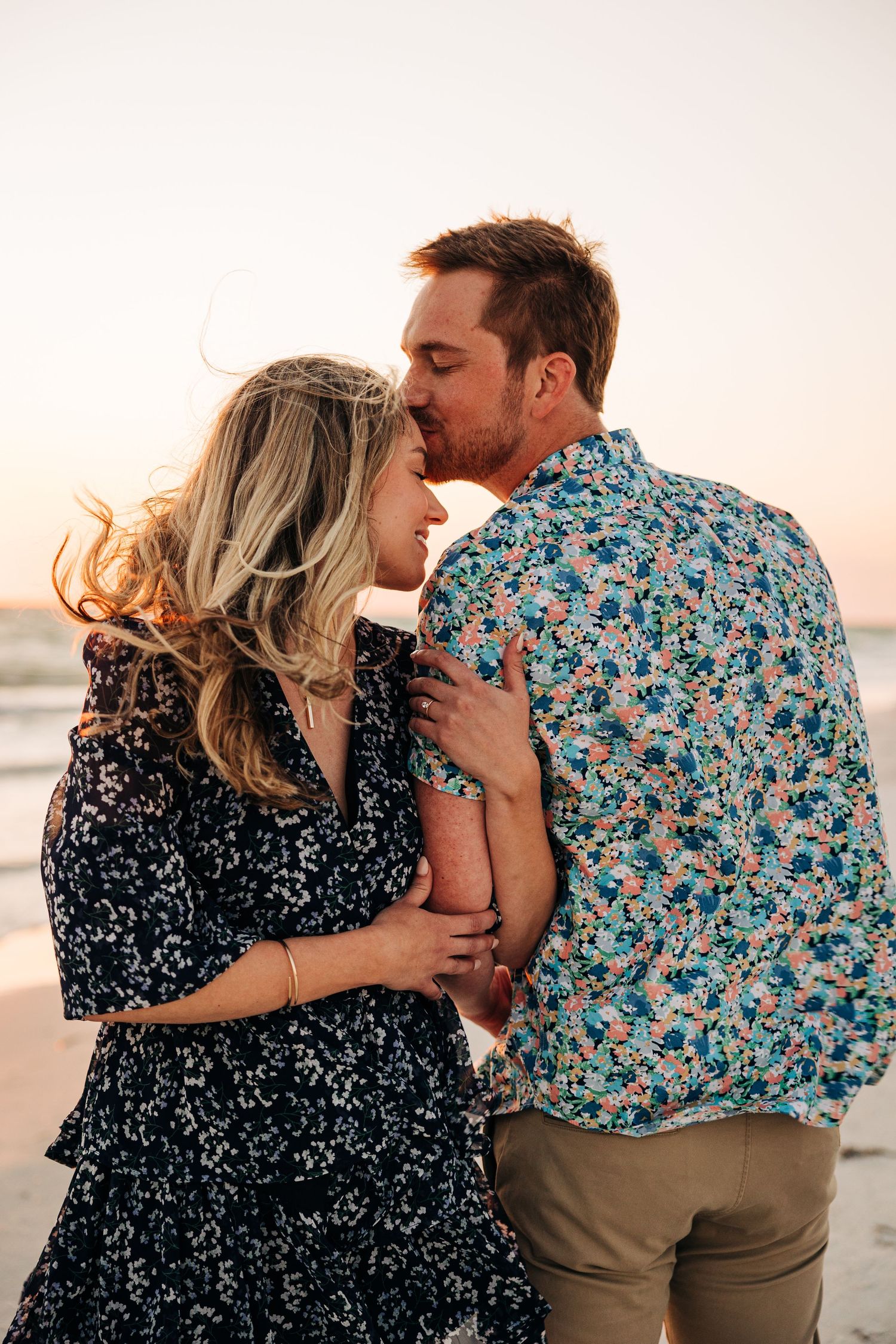 Newly engaged young beautiful couple in an embrace on Anna Maria Island taken by Sarasota Wedding Photographer.