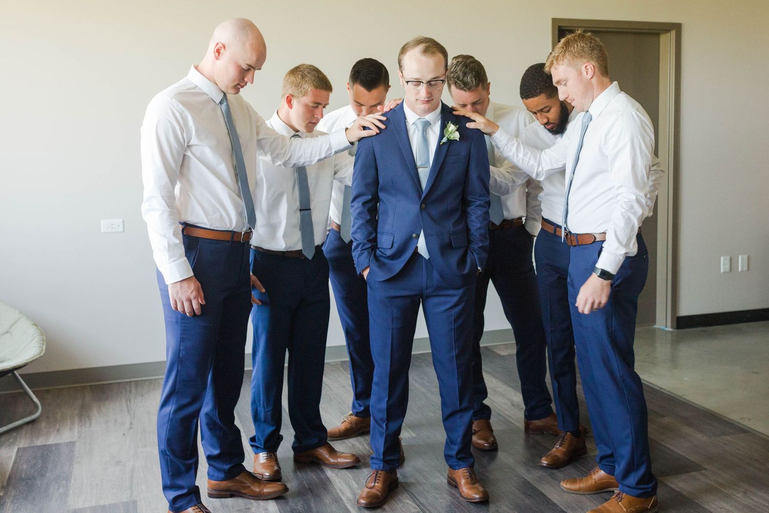 Groomsmen praying over groom before the ceremony