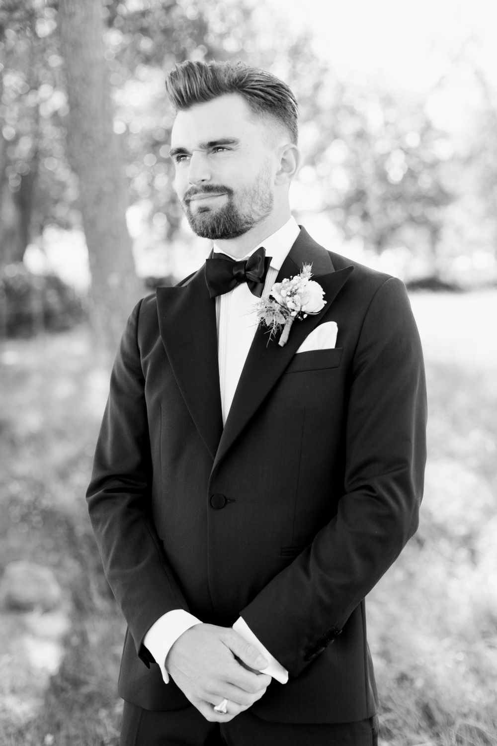 Classic black and white portrait of groom in tuxedo with boutonniere.