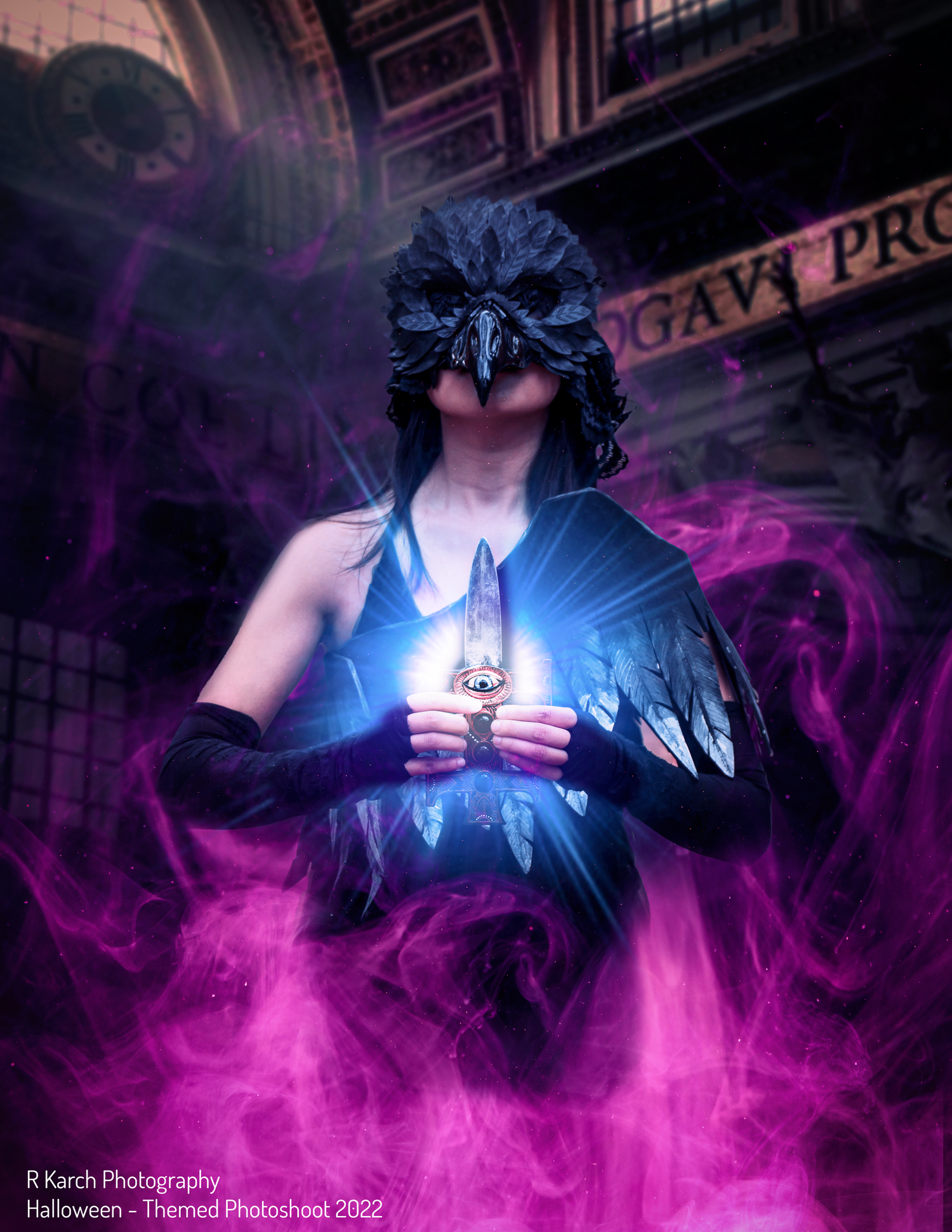 Mysterious figure in feathered mask surrounded by purple magical smoke and glowing blue light.