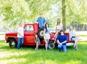 7 grandkids outside sitting on red truck