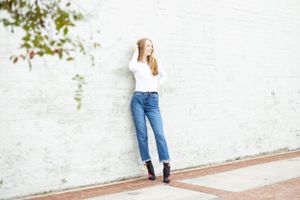 senior girl on white brick wall outside