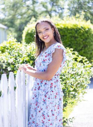 senior girl outside by white fence