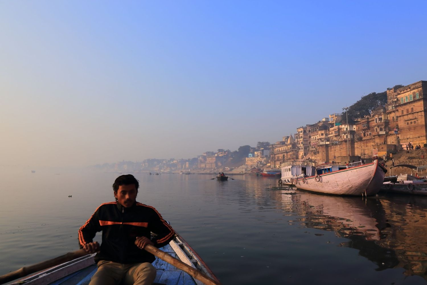 Early morning boat ride on the Ganges River with historic ghats of Varanasi in view.