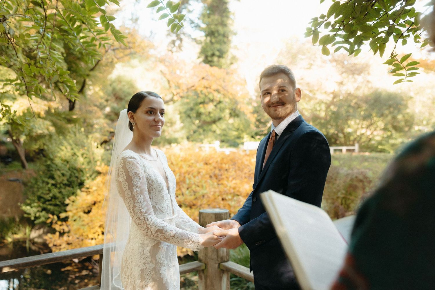 Outdoor autumn wedding ceremony with natural garden backdrop.