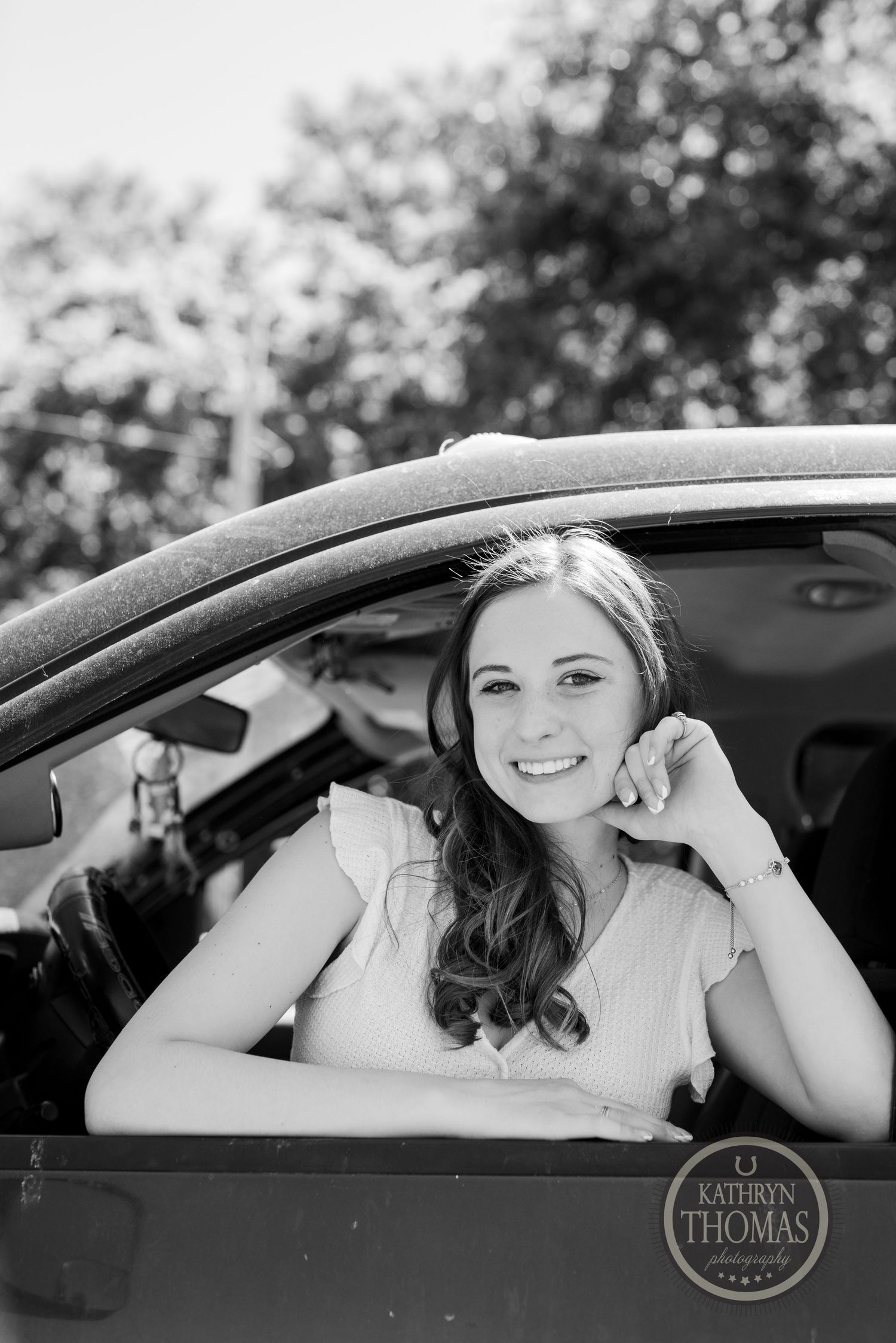 Black and white portrait of someone in a vehicle wearing white.