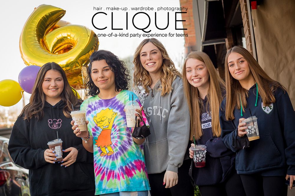 Five friends enjoying drinks together outdoors with yellow balloon decorations in casual attire.