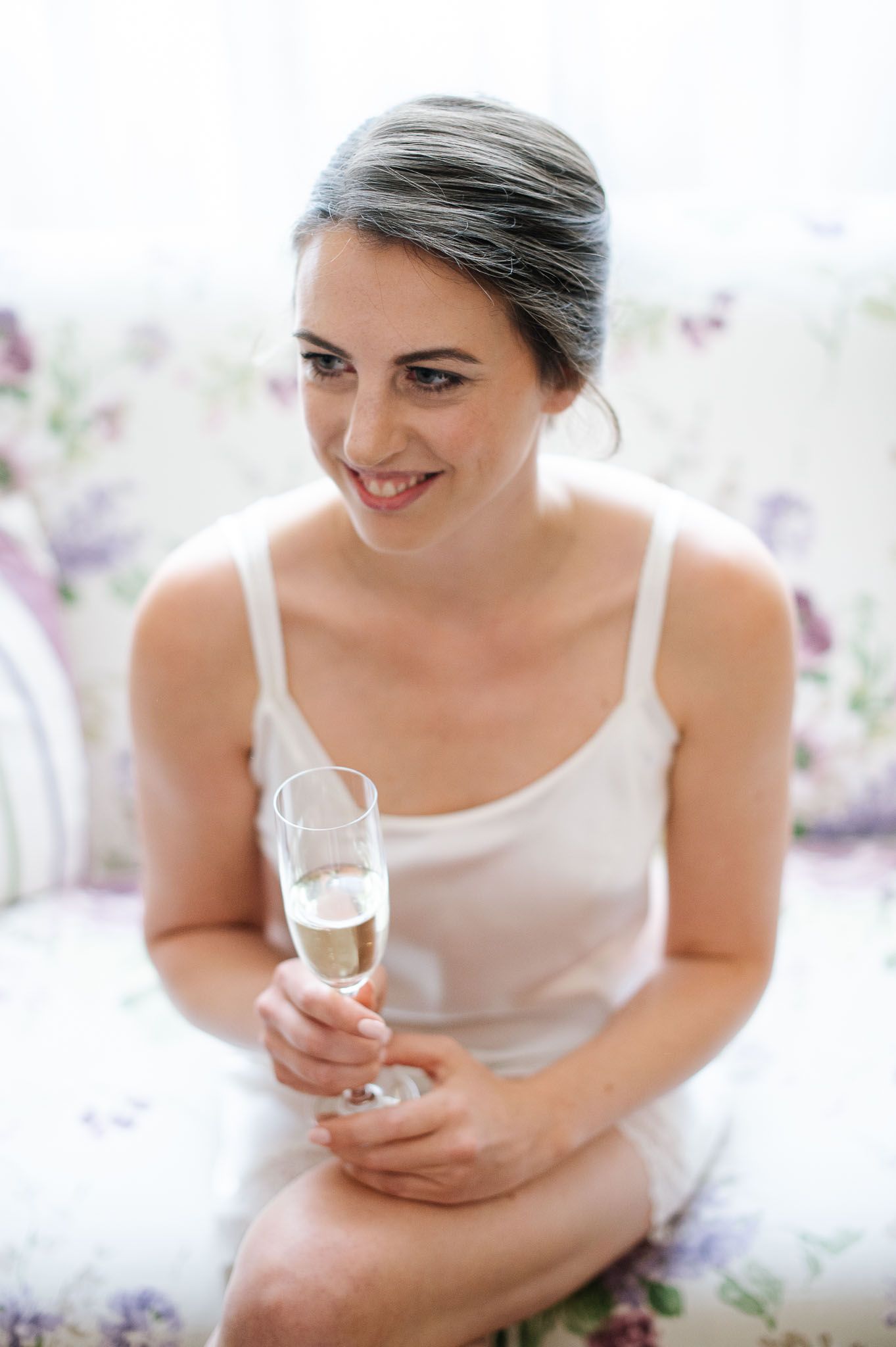 Intimate portrait in white showing joyful moment with champagne.