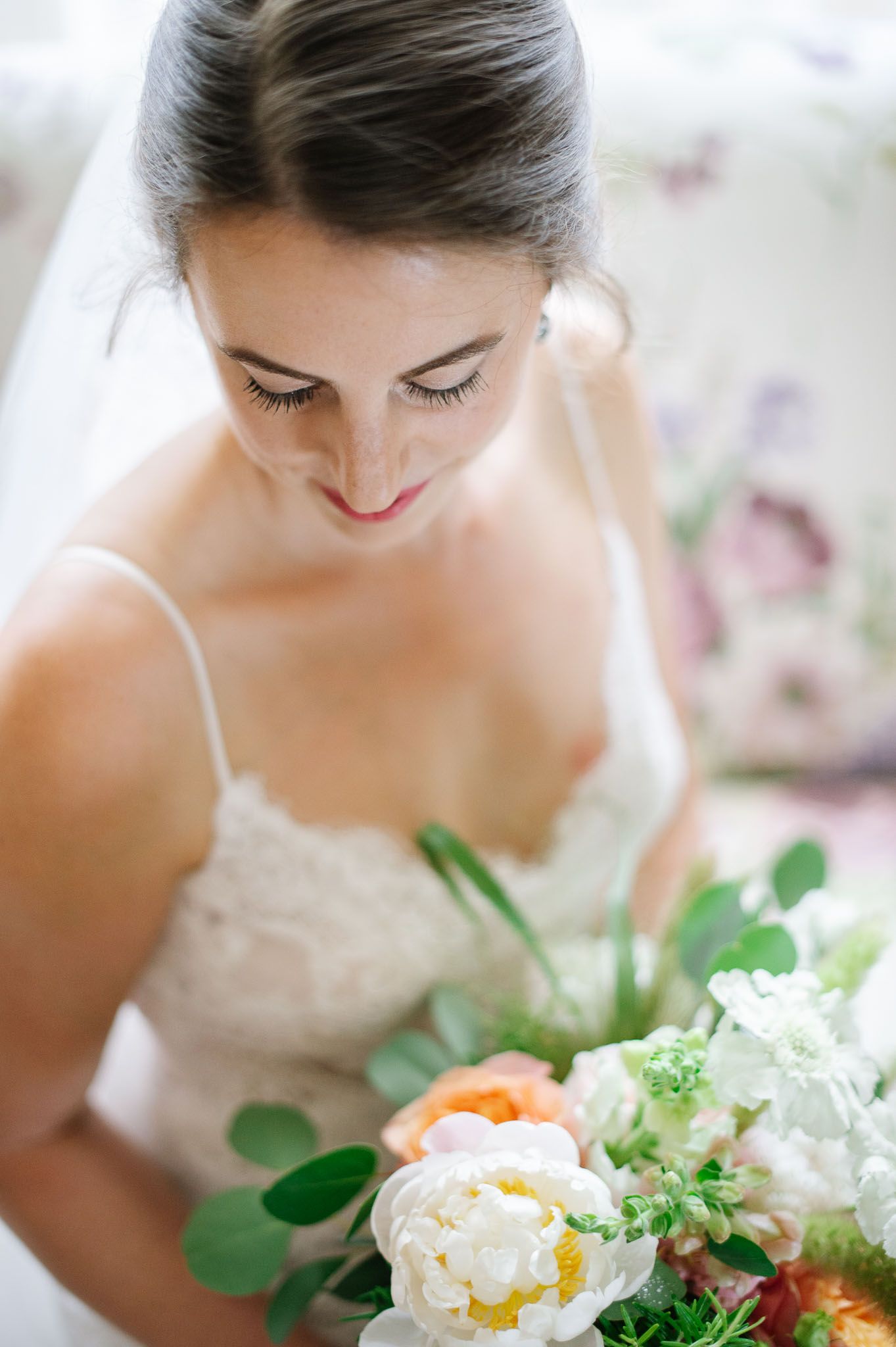 An elegant bridal bouquet features peach and white flowers with green foliage.
