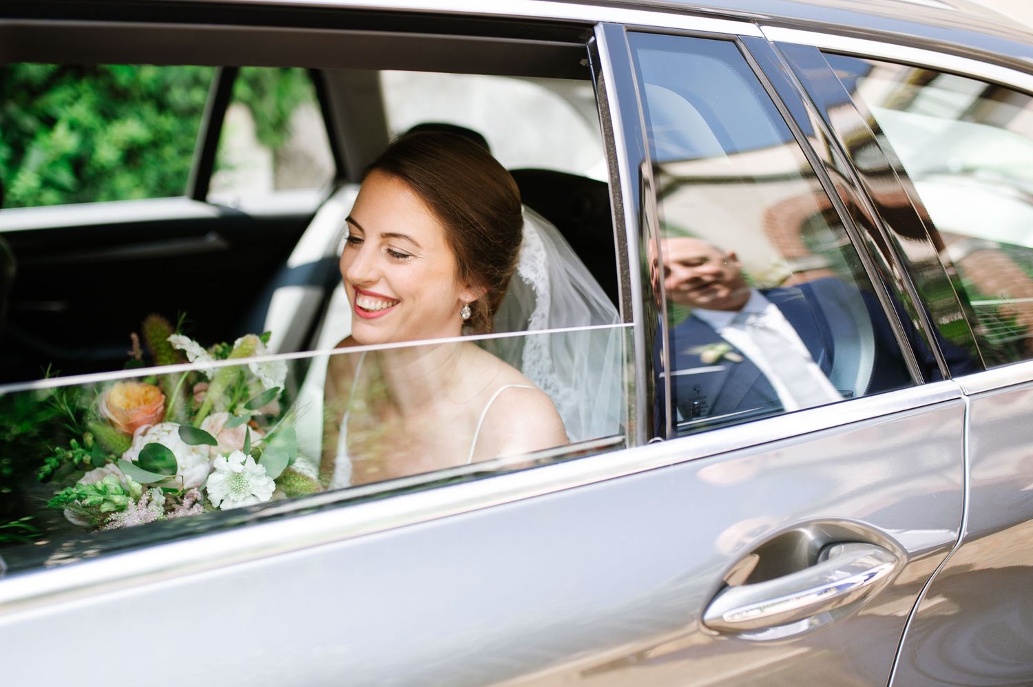View through car window of wedding party in formal attire.