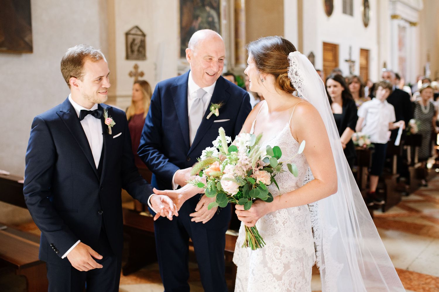 Traditional wedding ceremony taking place inside historic church with ornate architecture.