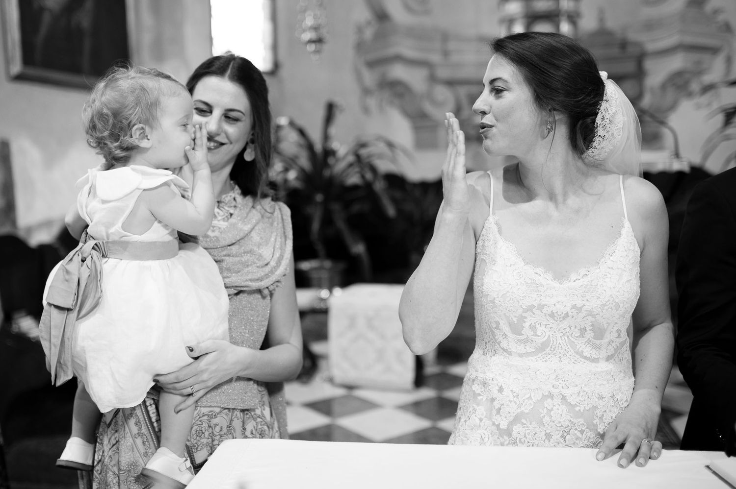 A heartwarming moment captured between wedding guests in black and white.