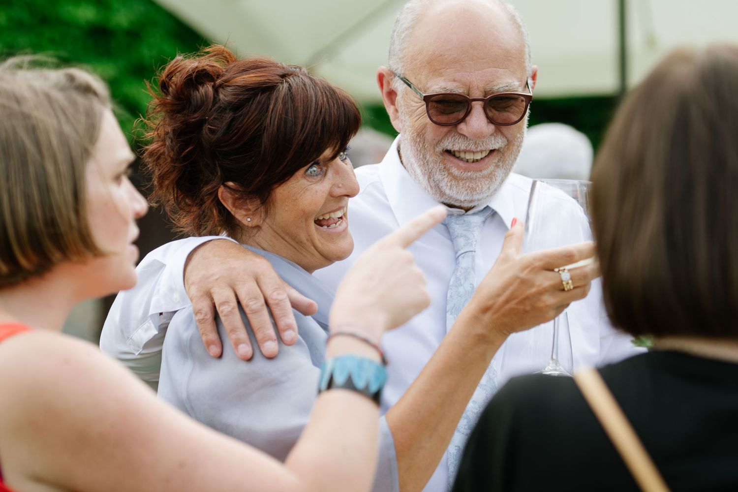 Joyful moments shared between guests at an outdoor wedding celebration.