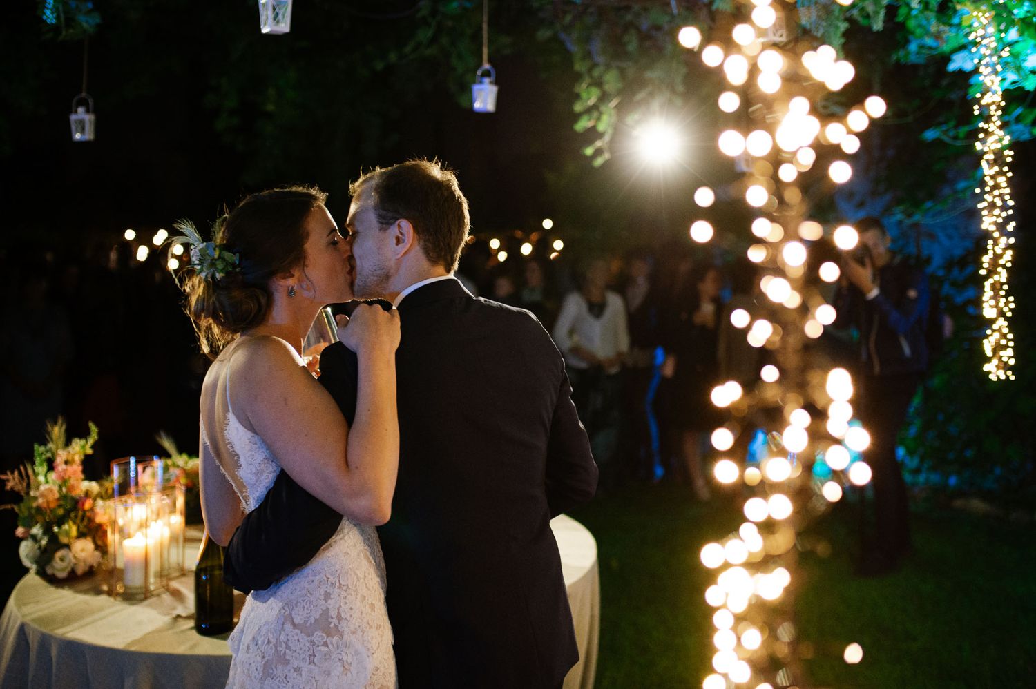 Romantic evening wedding reception scene with string lights and elegant decor creating a magical atmosphere.