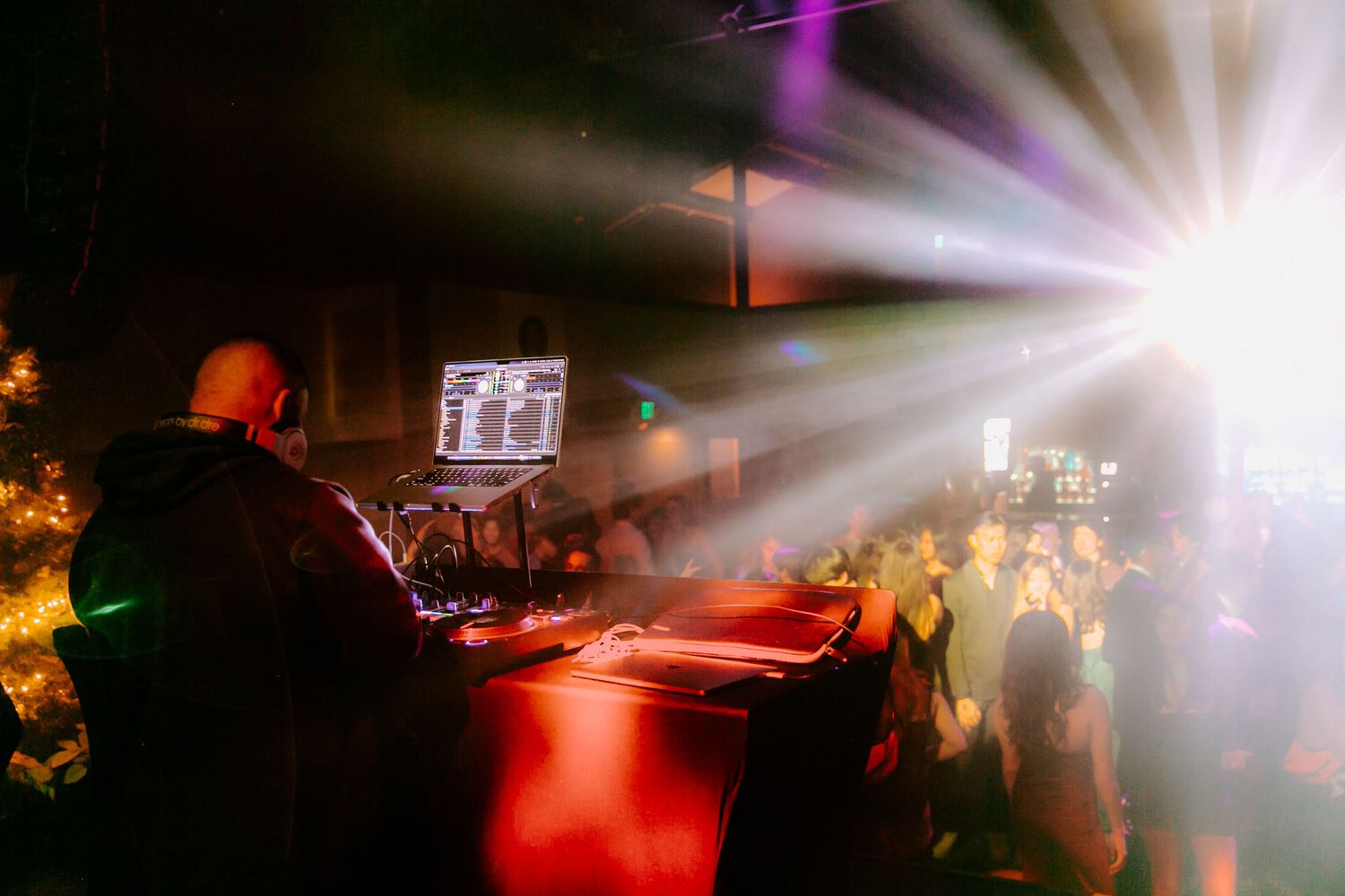 Colorful light beams illuminate dark dance floor at nighttime event.