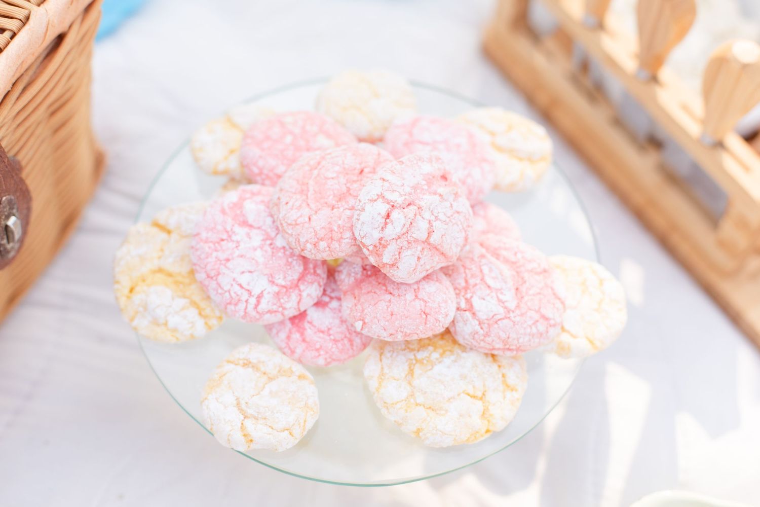Pink meringue cookies and treats arranged on white serving plates.