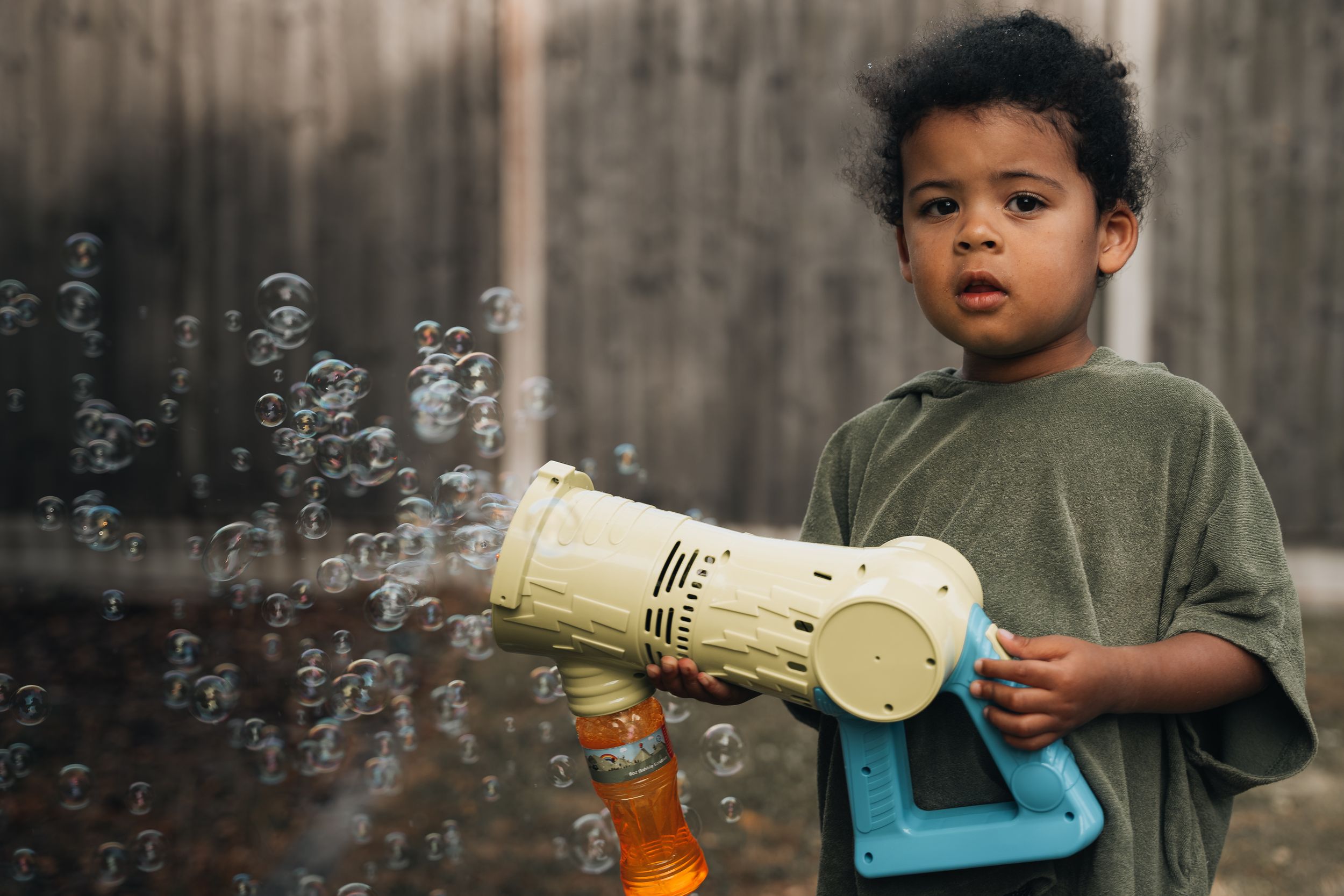 A series of shots showing bubble play against a wooden fence background.