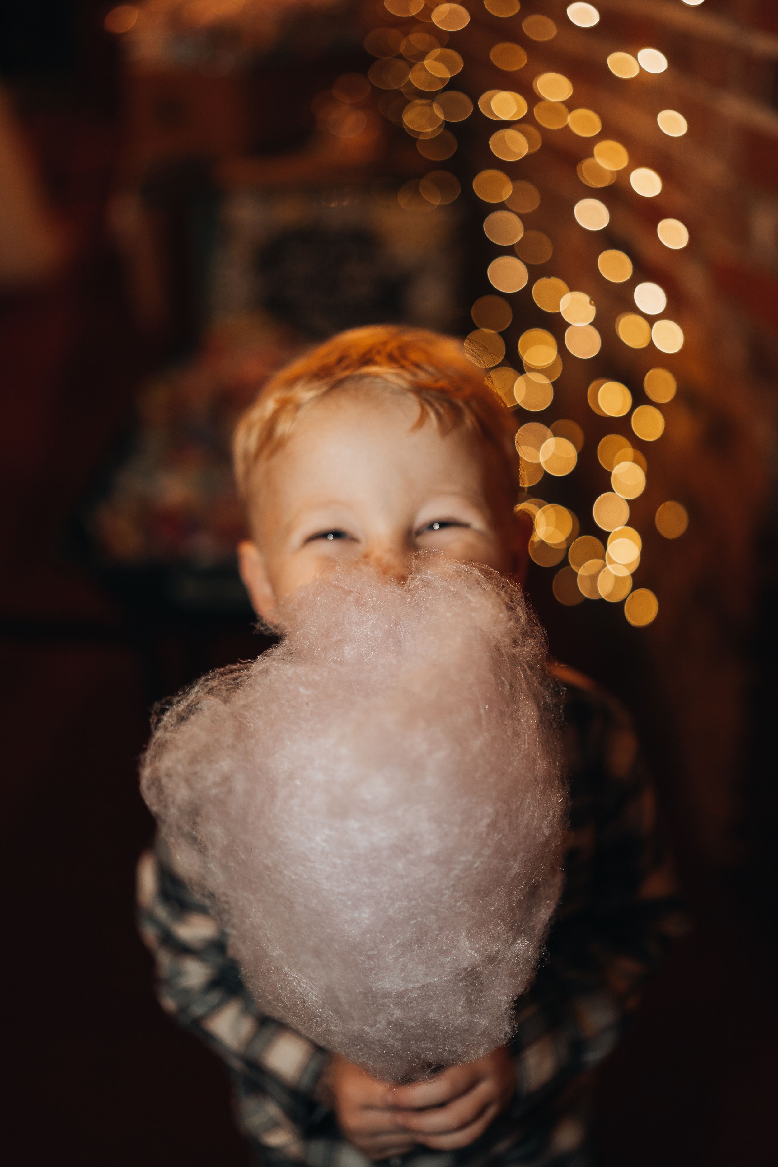 Cotton candy glows against a bokeh background of warm lights.