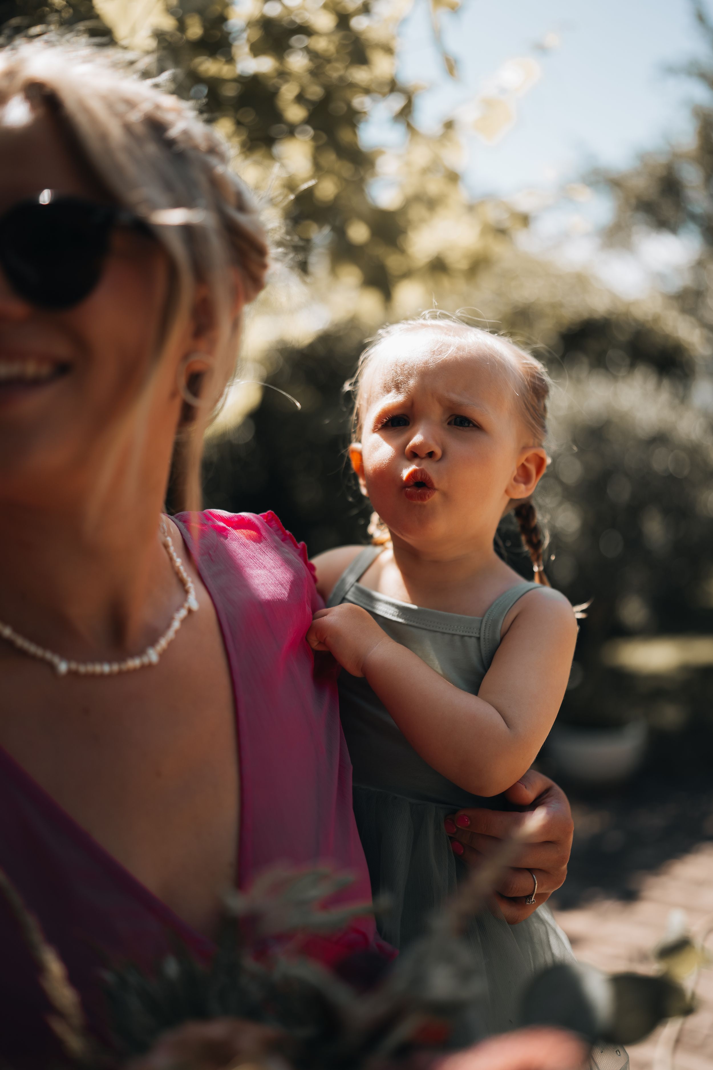Candid outdoor portrait showing loving interaction between adult and small child.