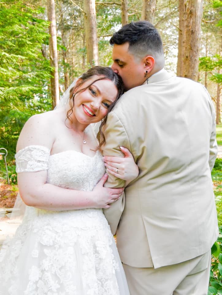 Romantic wedding photos of couple embracing in a sunlit forest setting.