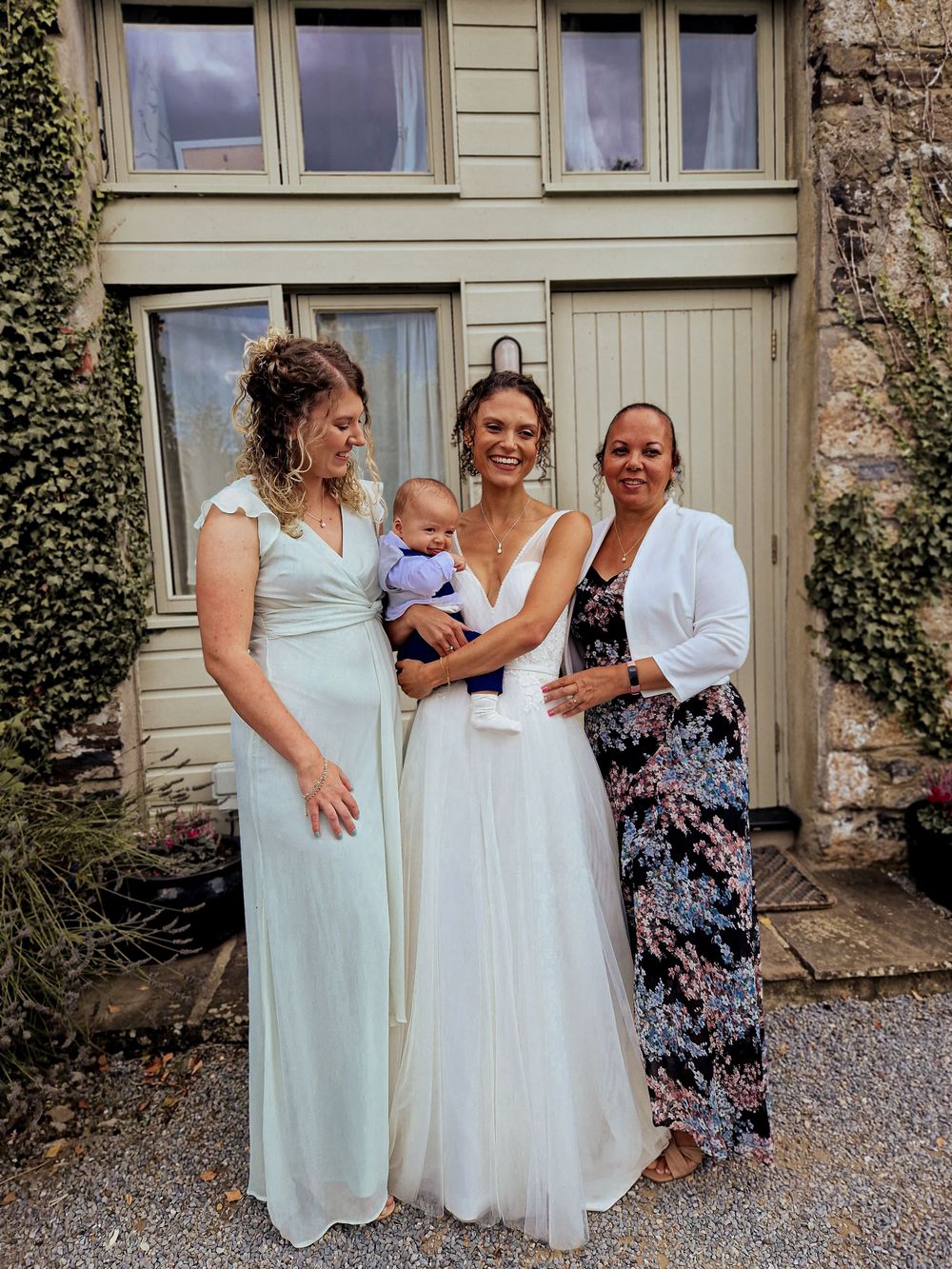 bride holding her son with her mother and sister by her side on her wedding day by Dominique Lauren Photography