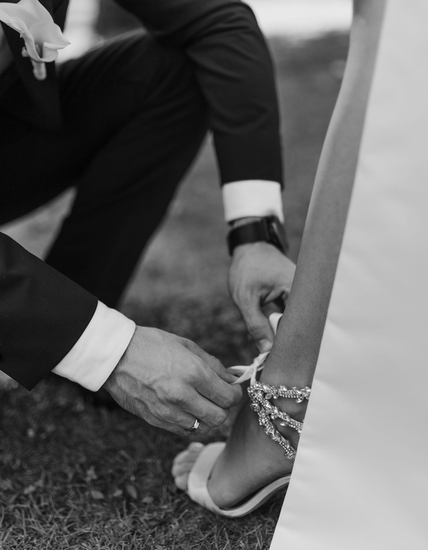 Black and white detail shot of adjusting bridal shoe strap.