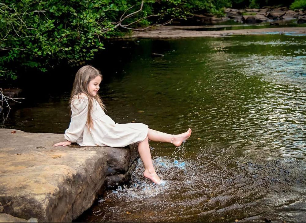 Artistic creek photoshoot with reflections in the water.