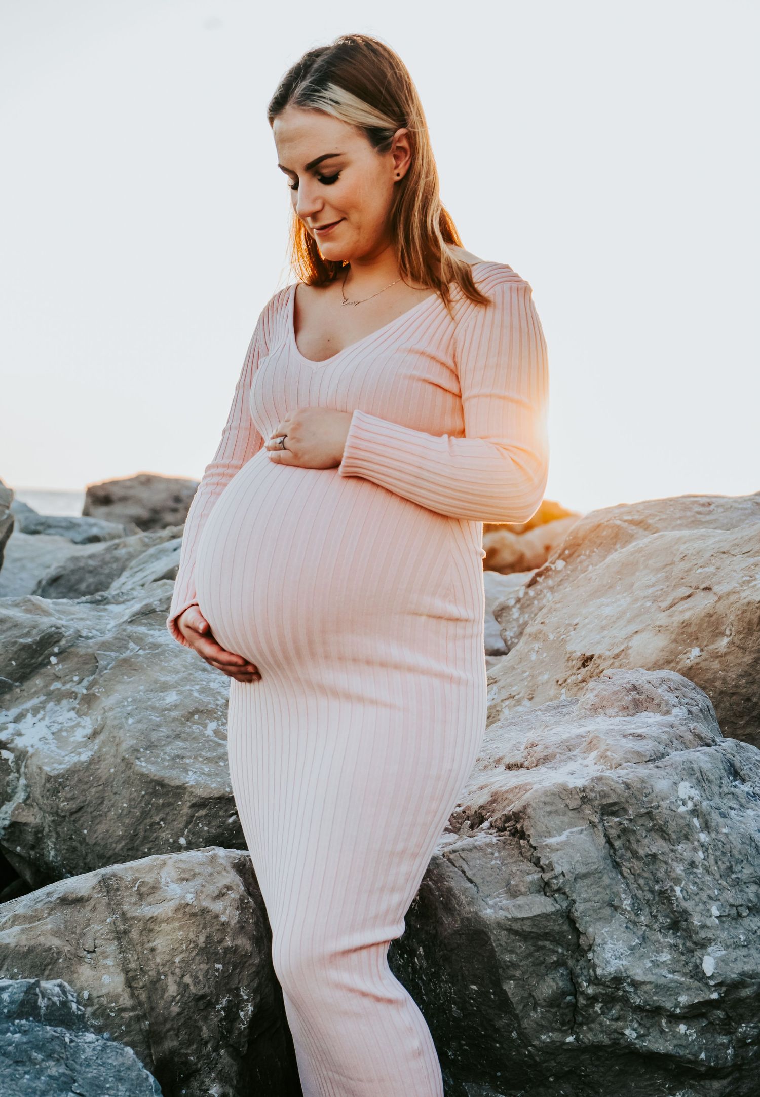 Maternity Session at Upham Beach in Pinellas County - mother holding baby bump at sunset