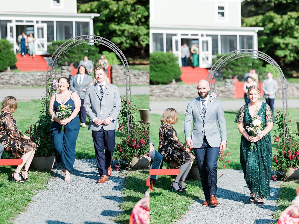 Wedding party members walking down aisle under metal arch decorated with flowers.