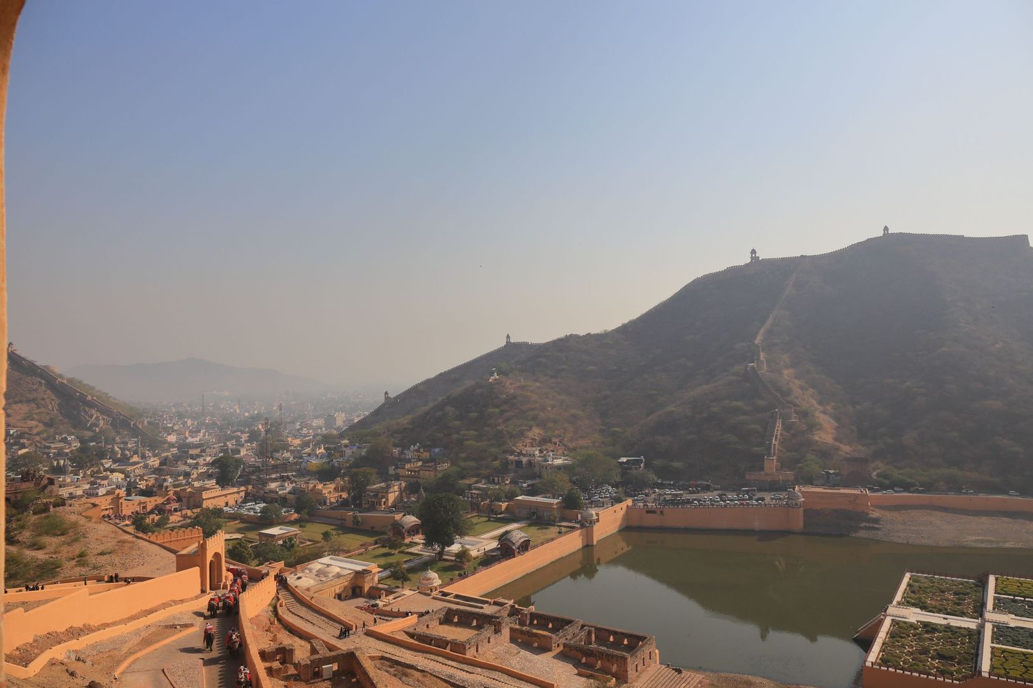 Panoramic view of Amber Fort and city walls with water reservoir in Jaipur, India.