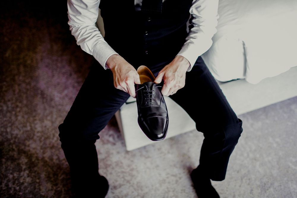 groom adjusting shoes to put on