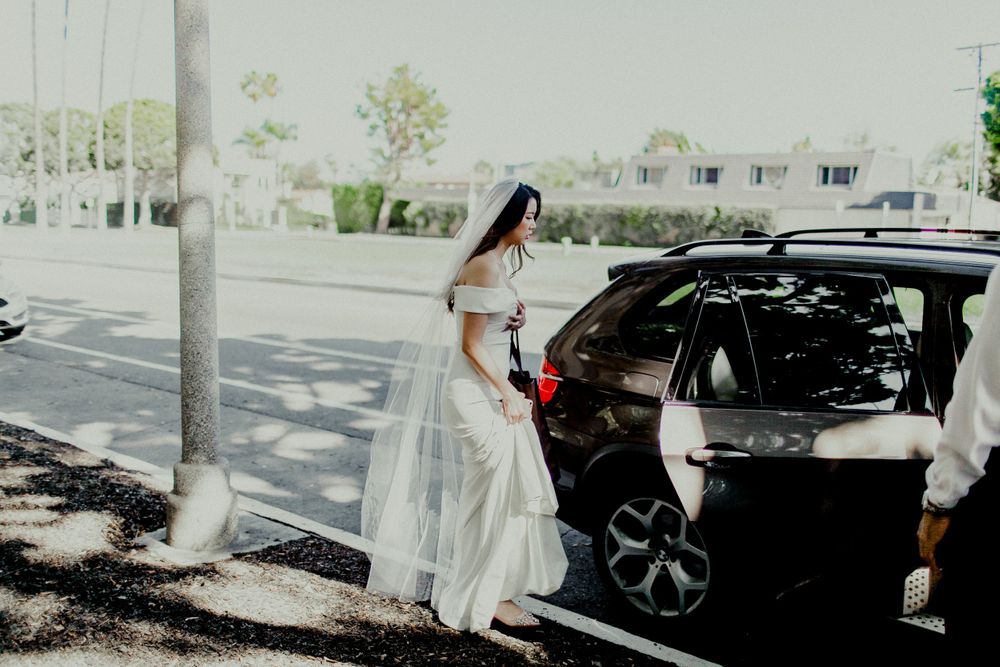bride entering car heading to ceremony and reception venue