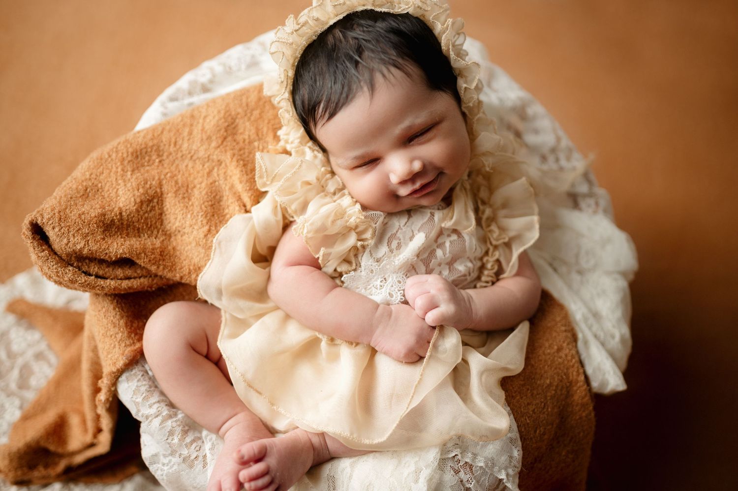 Sweet newborn photography session featuring baby in vintage-inspired cream lace setting.