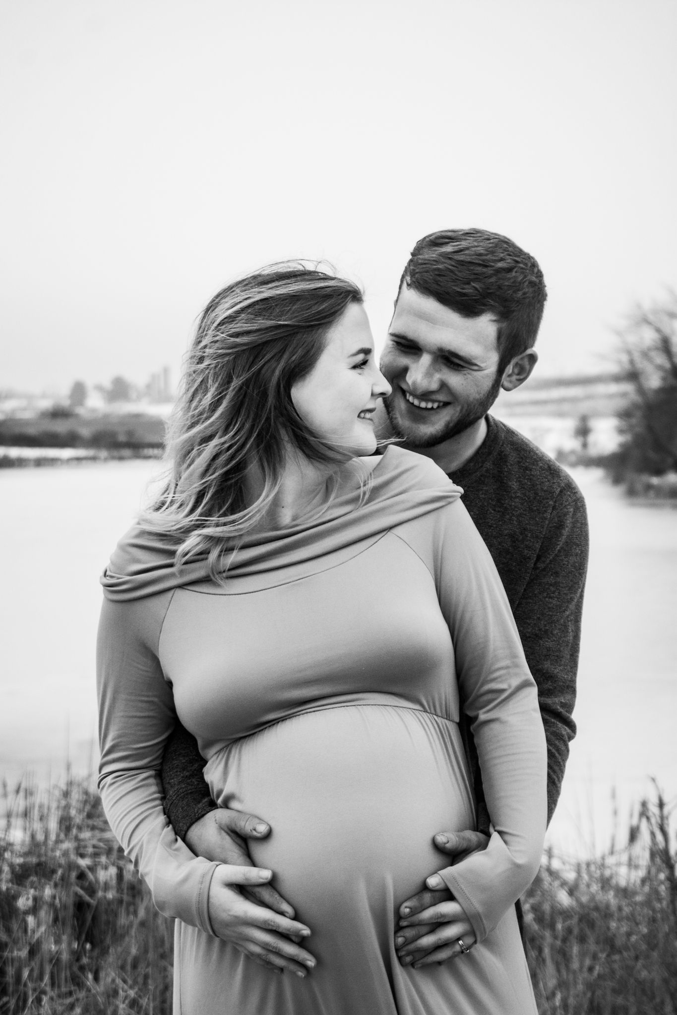 An intimate black and white maternity photo captured by the water.