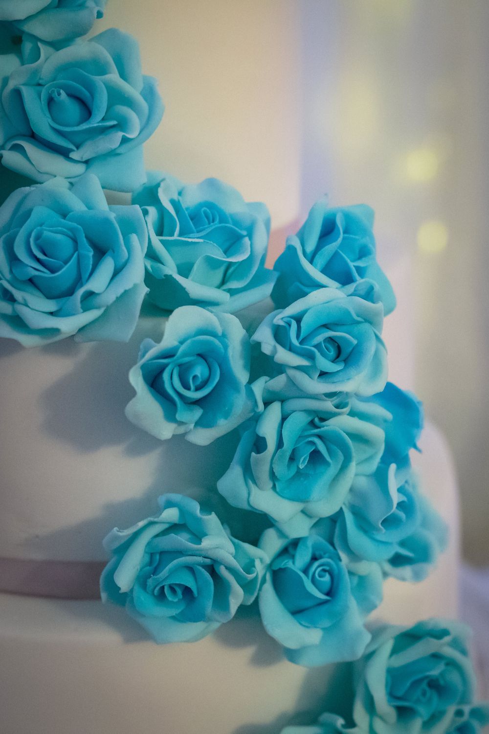 turquoise flowers cascade down the wedding cake