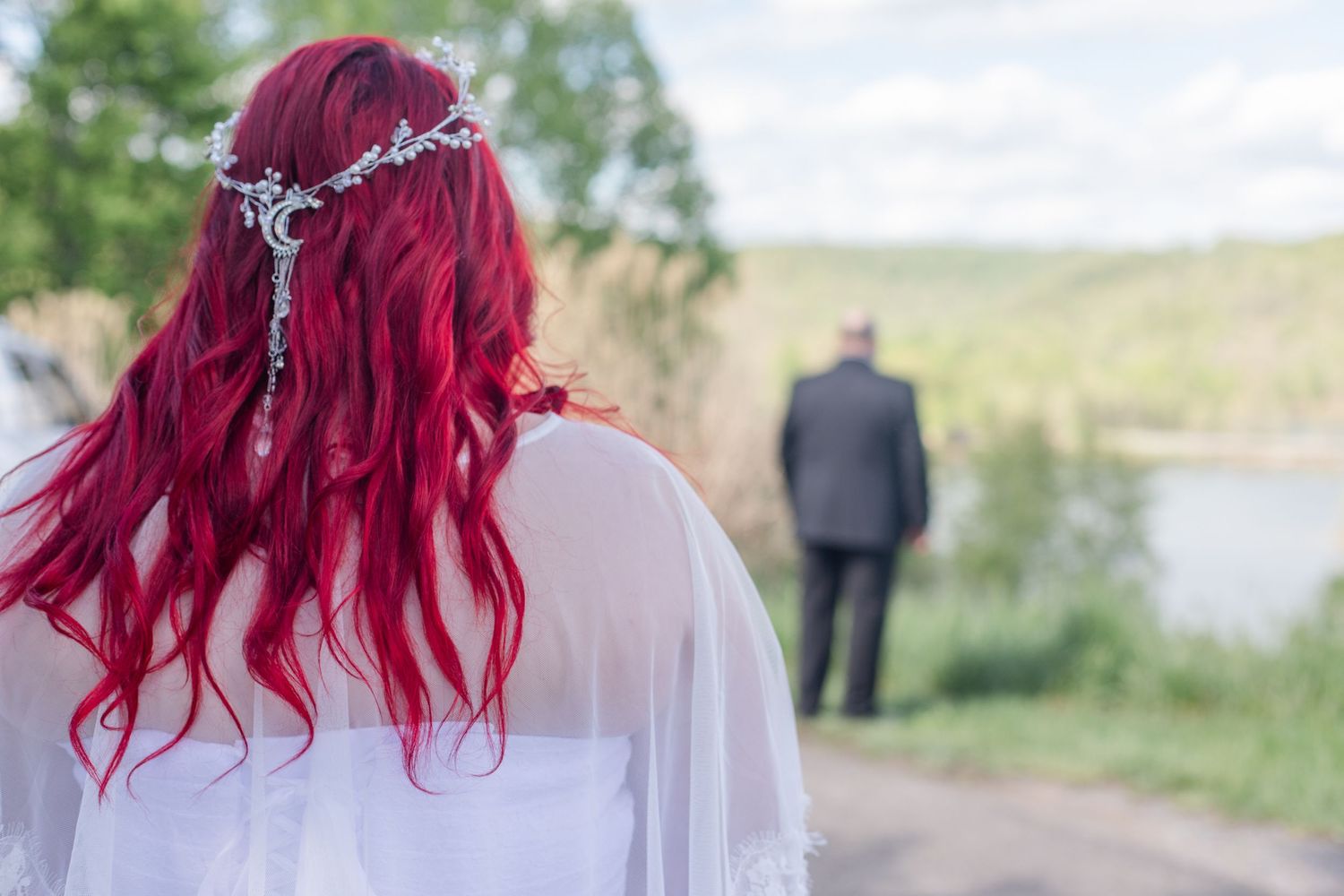 Outdoor wedding ceremony with vibrant red accents against a scenic mountain backdrop.