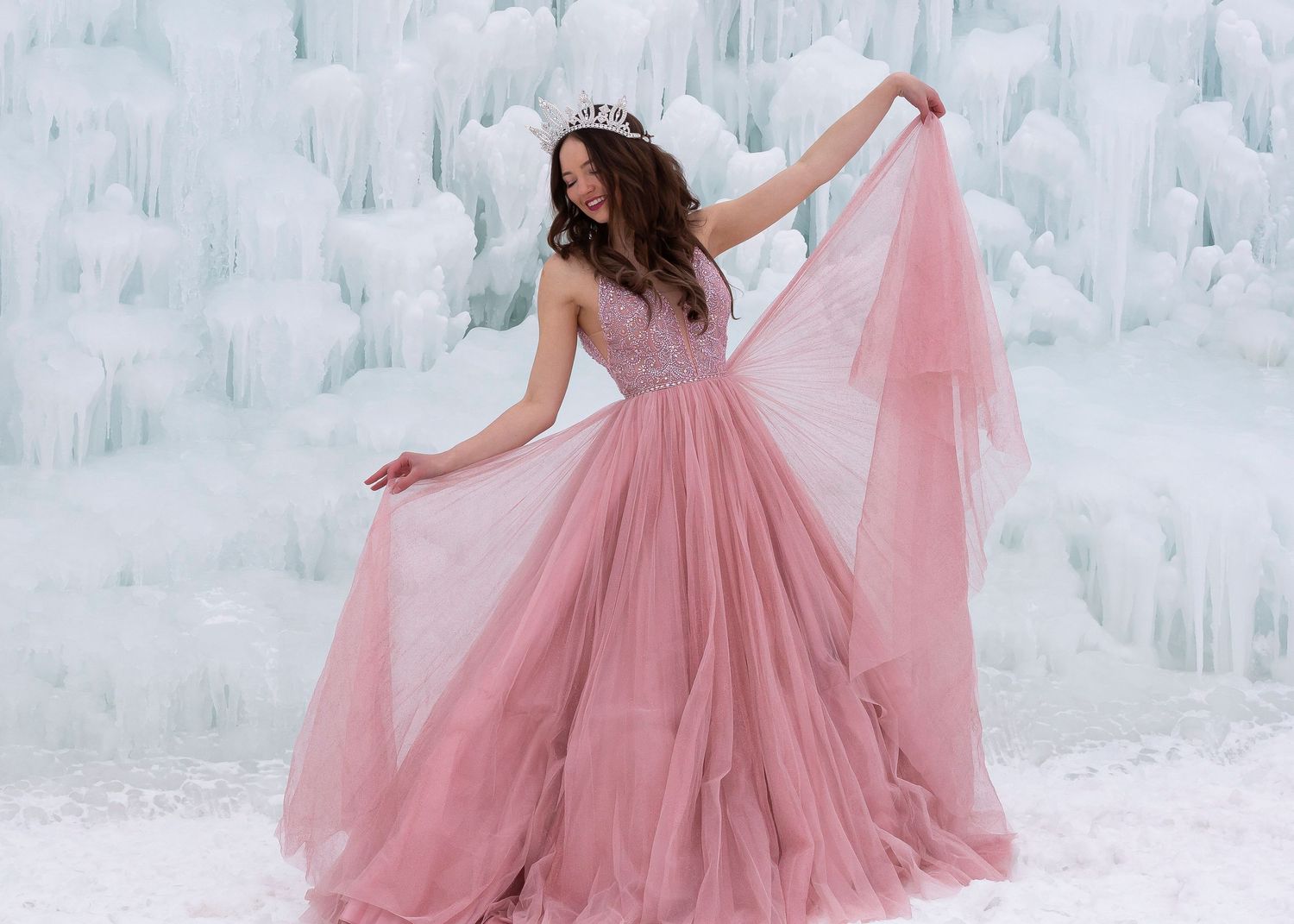 senior posed at the utah ice castle with pink formal pageant gown and tiara