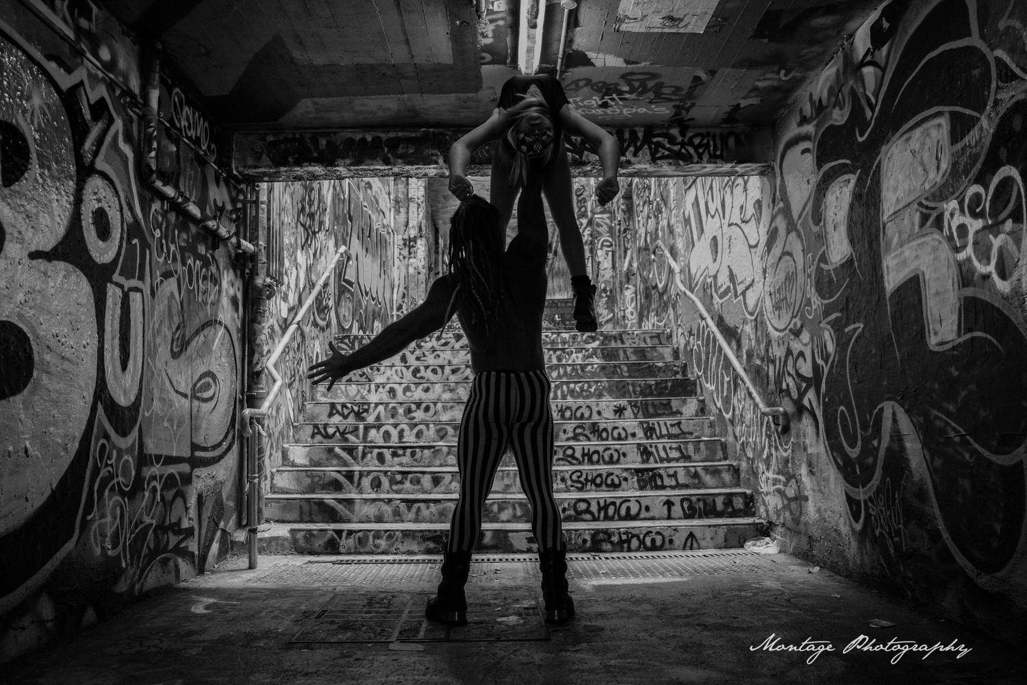 Silhouette in graffiti tunnel creates dramatic black and white composition.