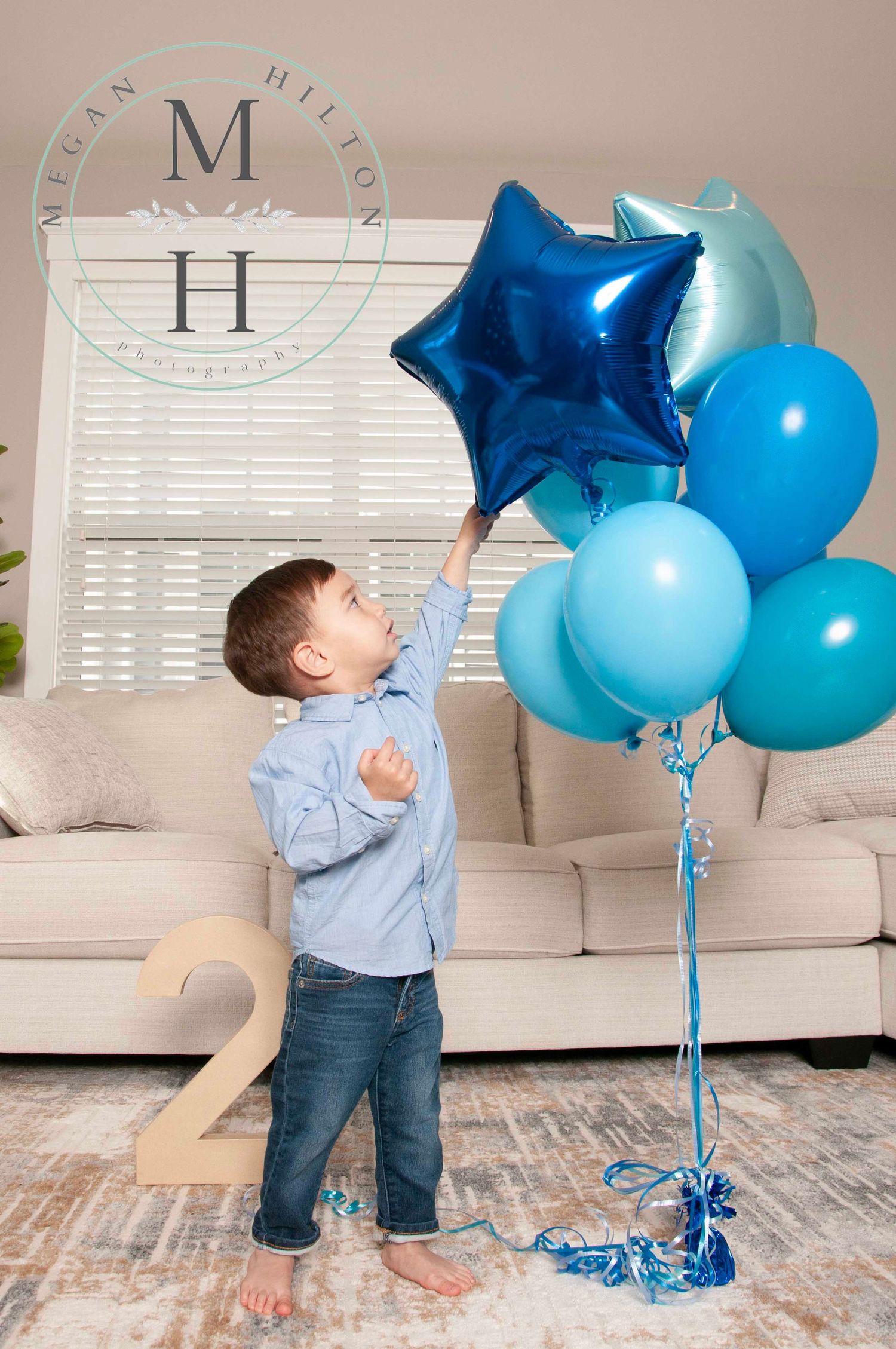 Little boy touching birthday balloons