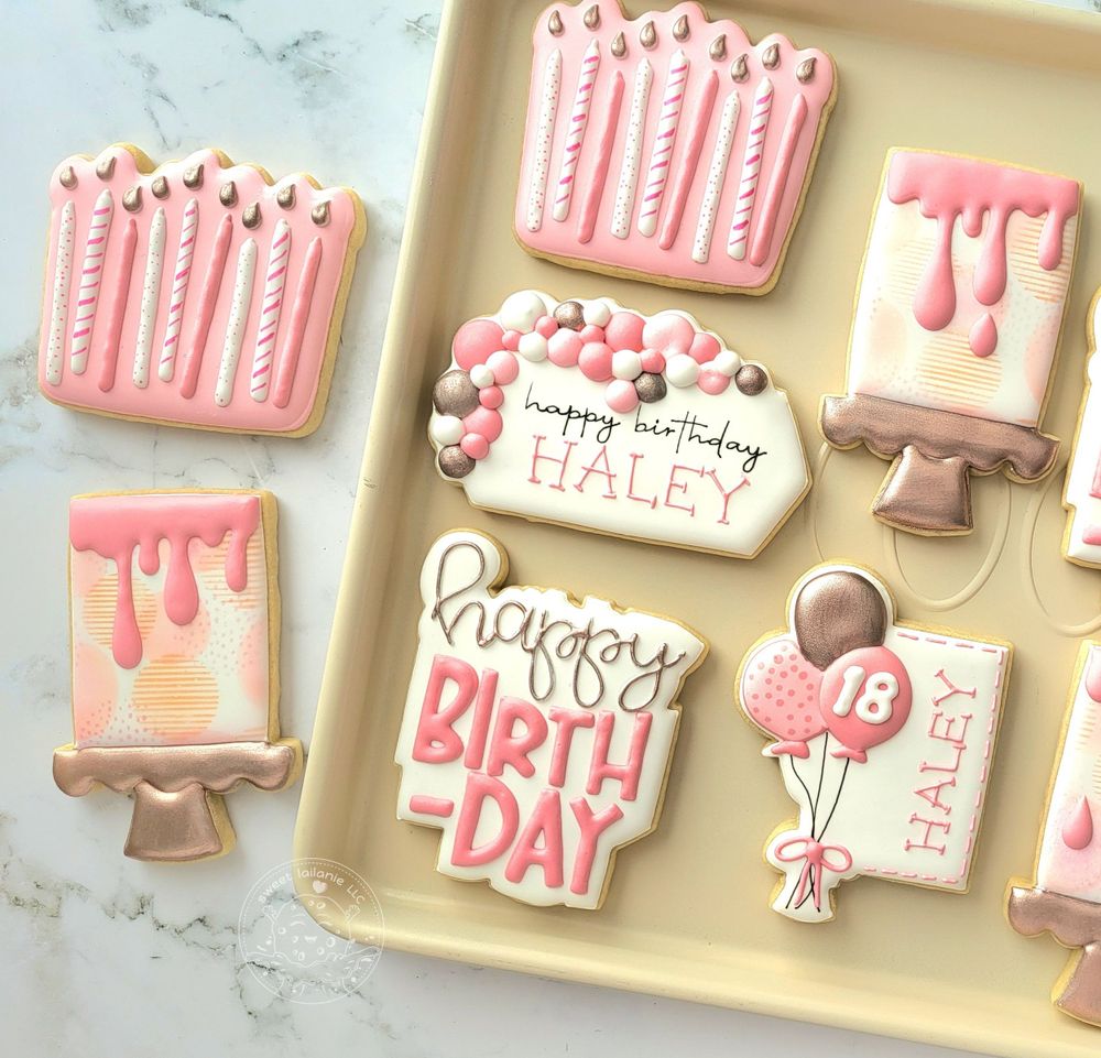 18th Birthday cookies which include cake, candles and balloons in shades of pink and gold.