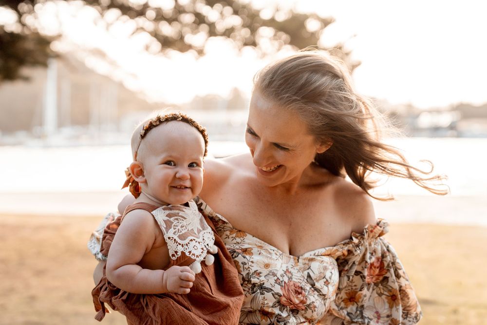 Giggling baby with mother during a family photoshoot at the northern beaches