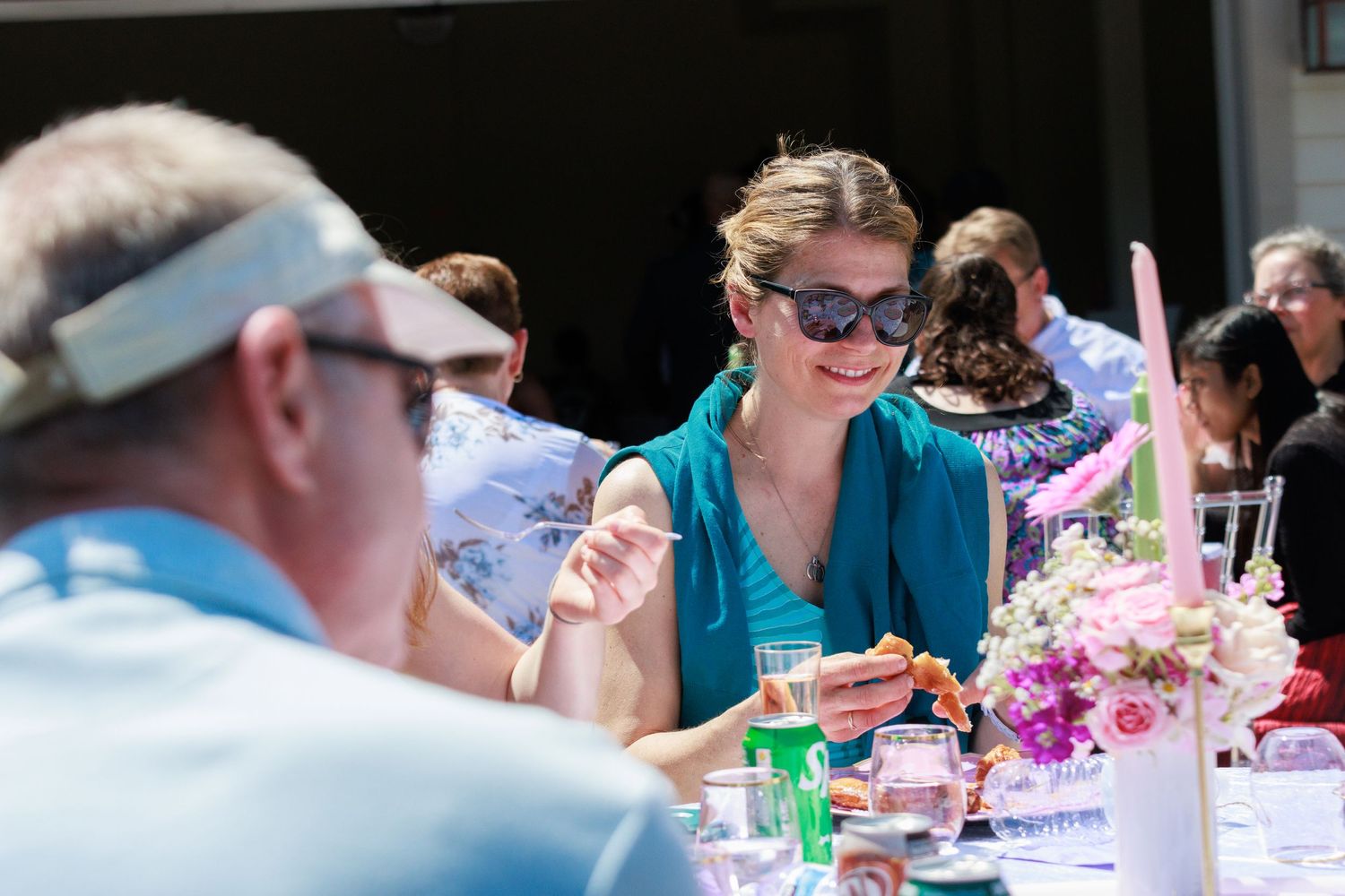 Guests enjoying food and conversation at an outdoor dining event.