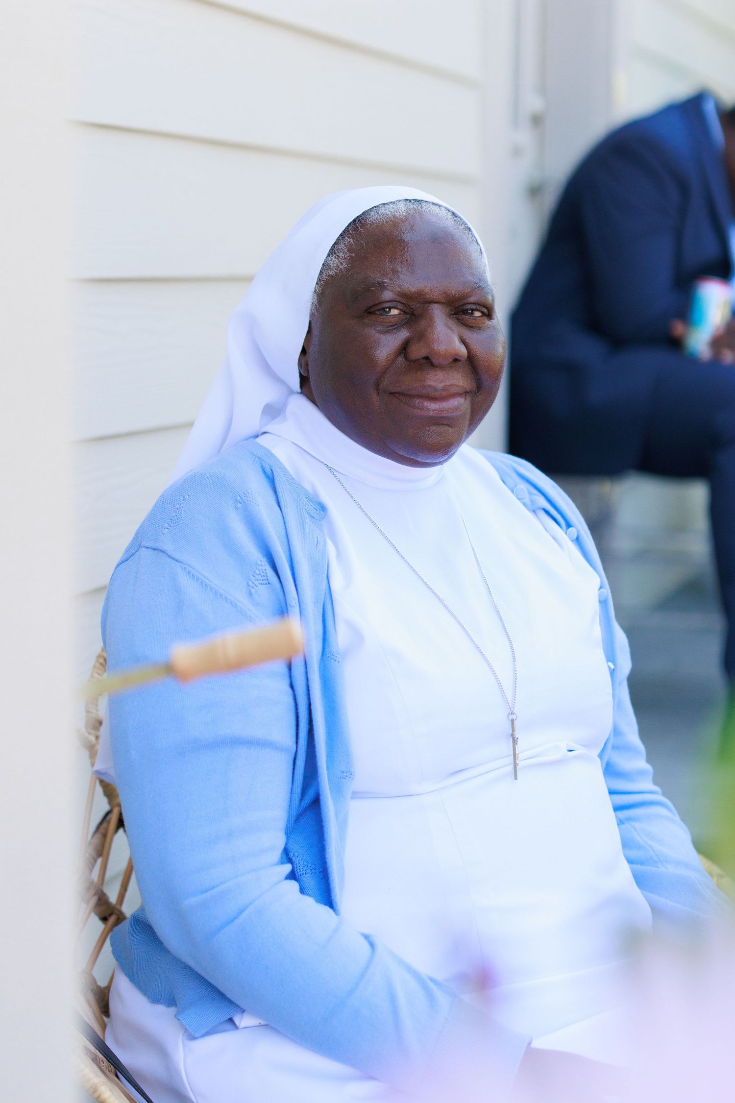 A sister in traditional religious habit wearing blue and white smiles warmly.