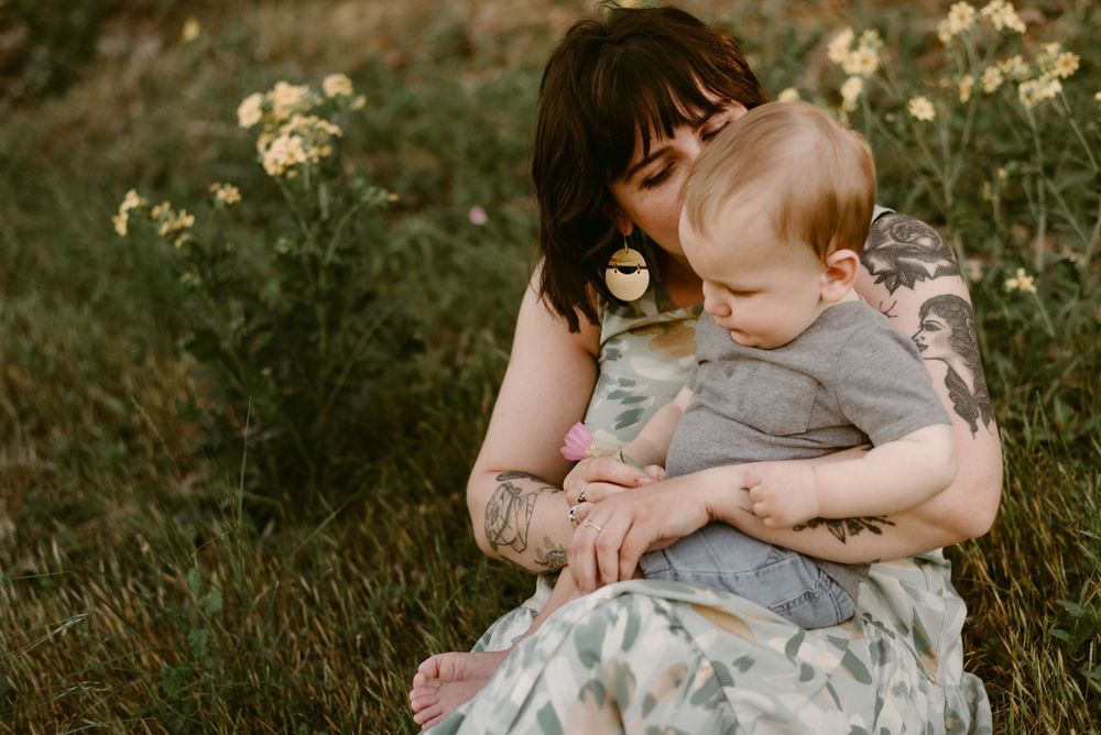 Intimate portrait of parent and child sitting together in golden evening light.