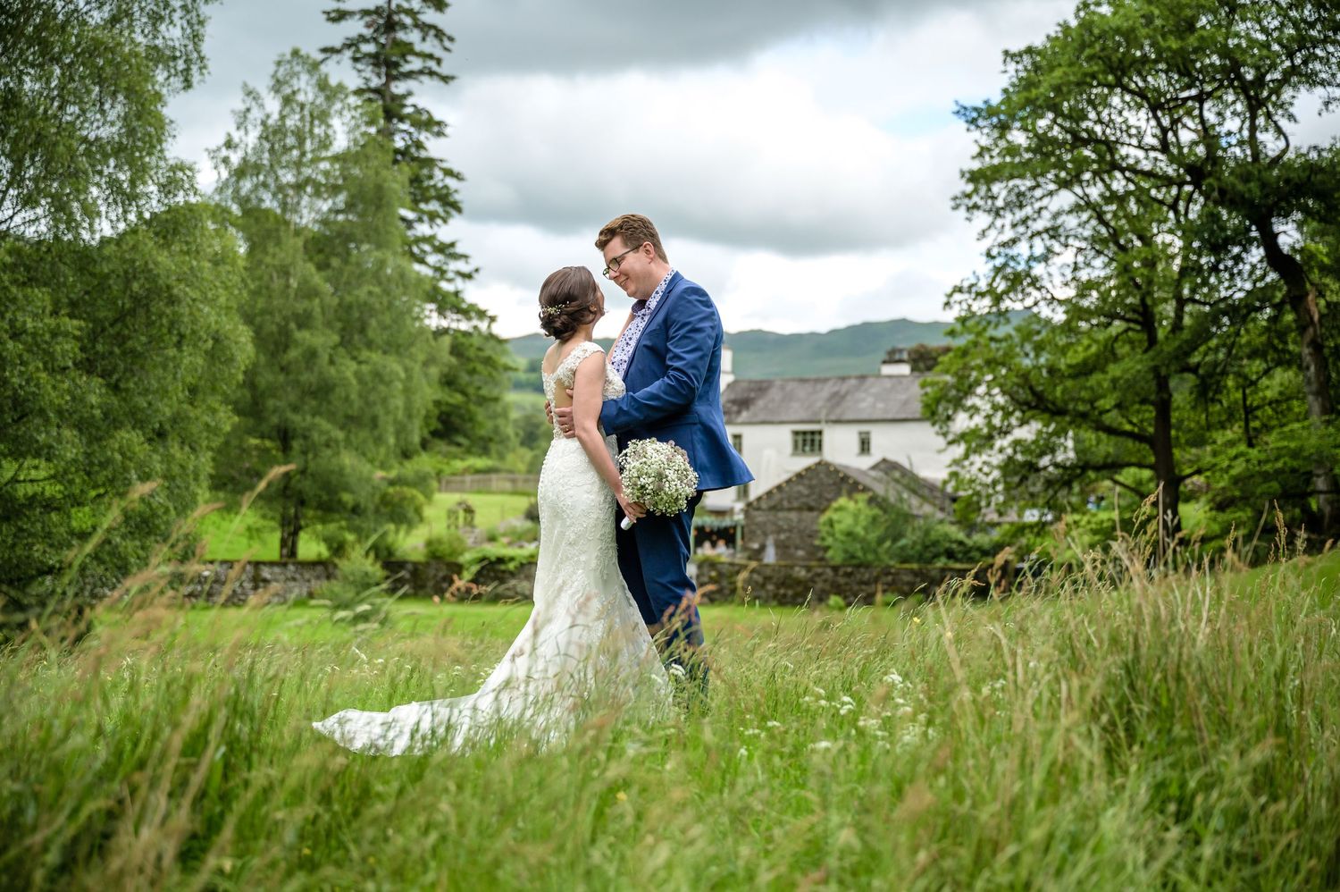 Bride and groom in meadow by Rydal Water after Cote How wedding