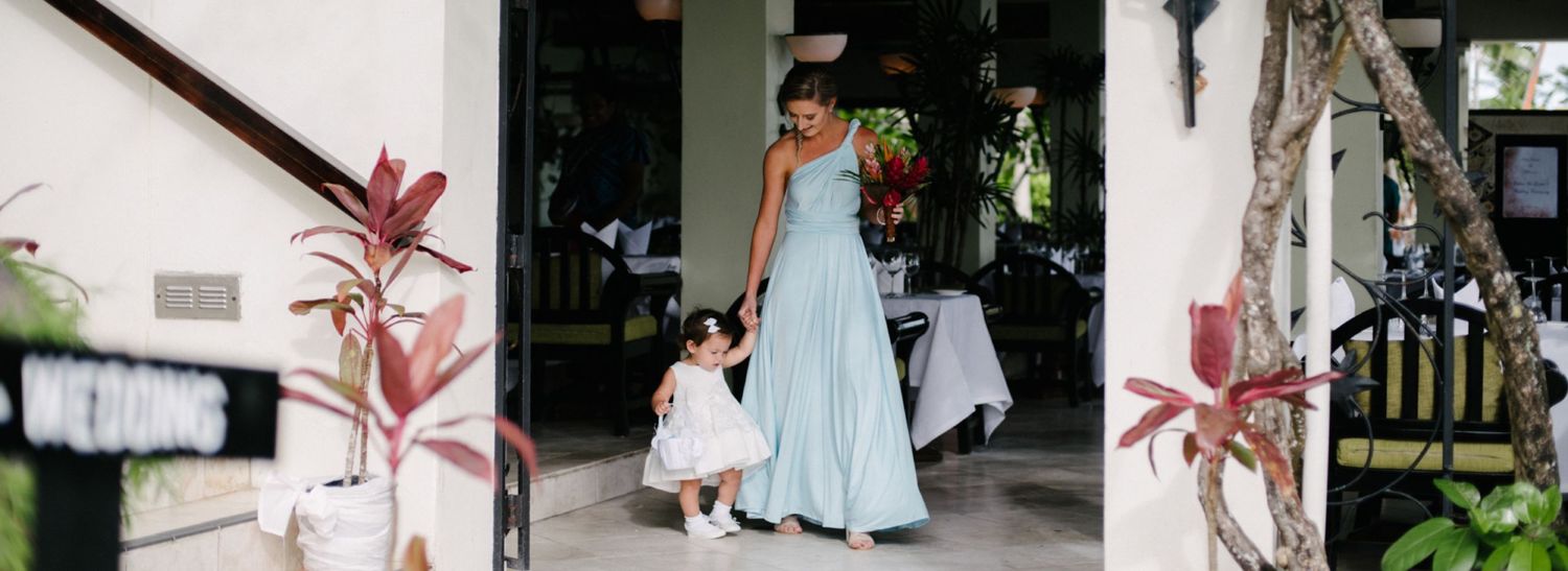 Mother and daughter in matching blue gowns walking together outside.