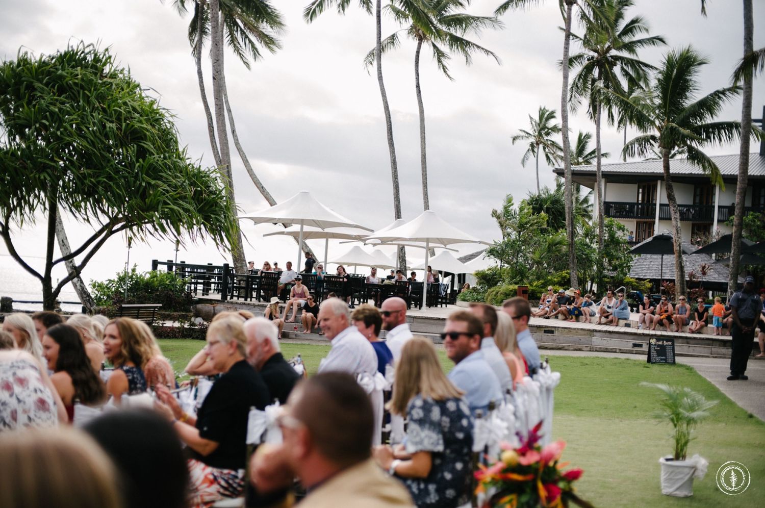Tropical beachside wedding ceremony with palm trees and ocean views.
