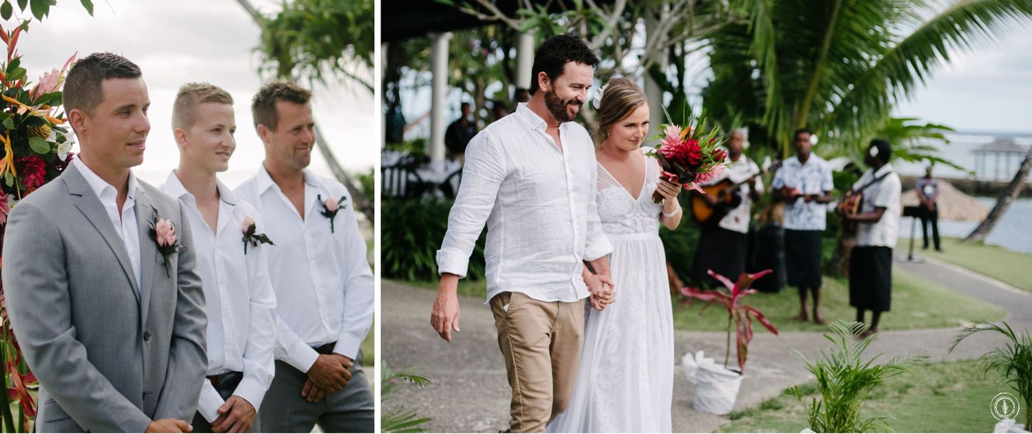 Wedding ceremony participants standing under tropical greenery and flowers.