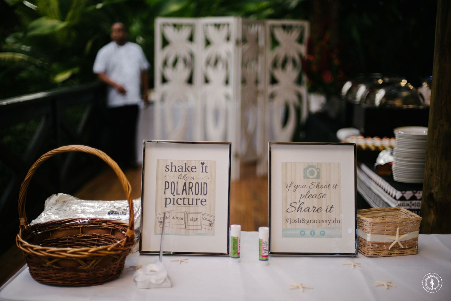 Wedding reception details with rustic signage and decorative elements on a wooden table.
